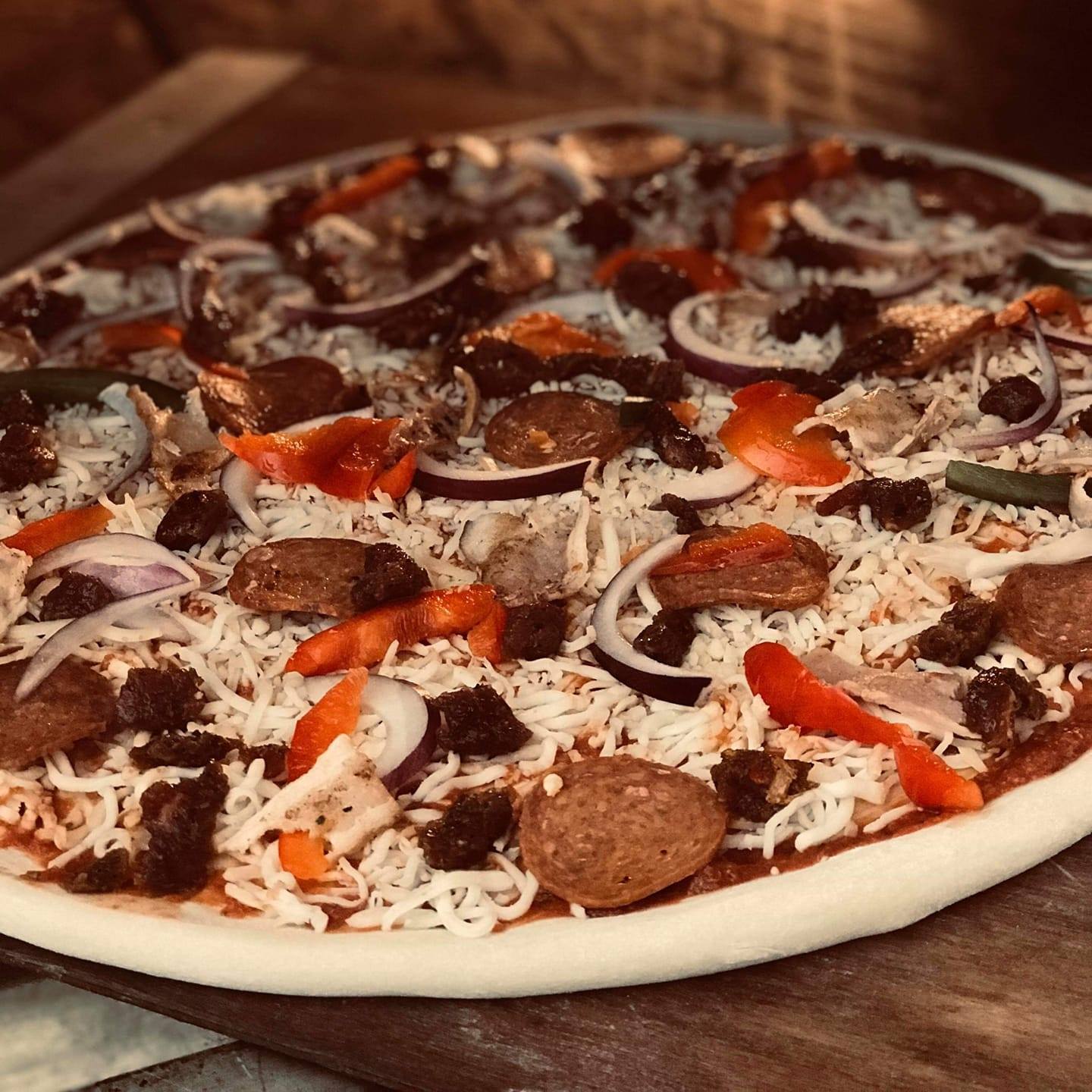 Homemade pizza ready for the oven, featuring rich flavors and quality ingredients.
