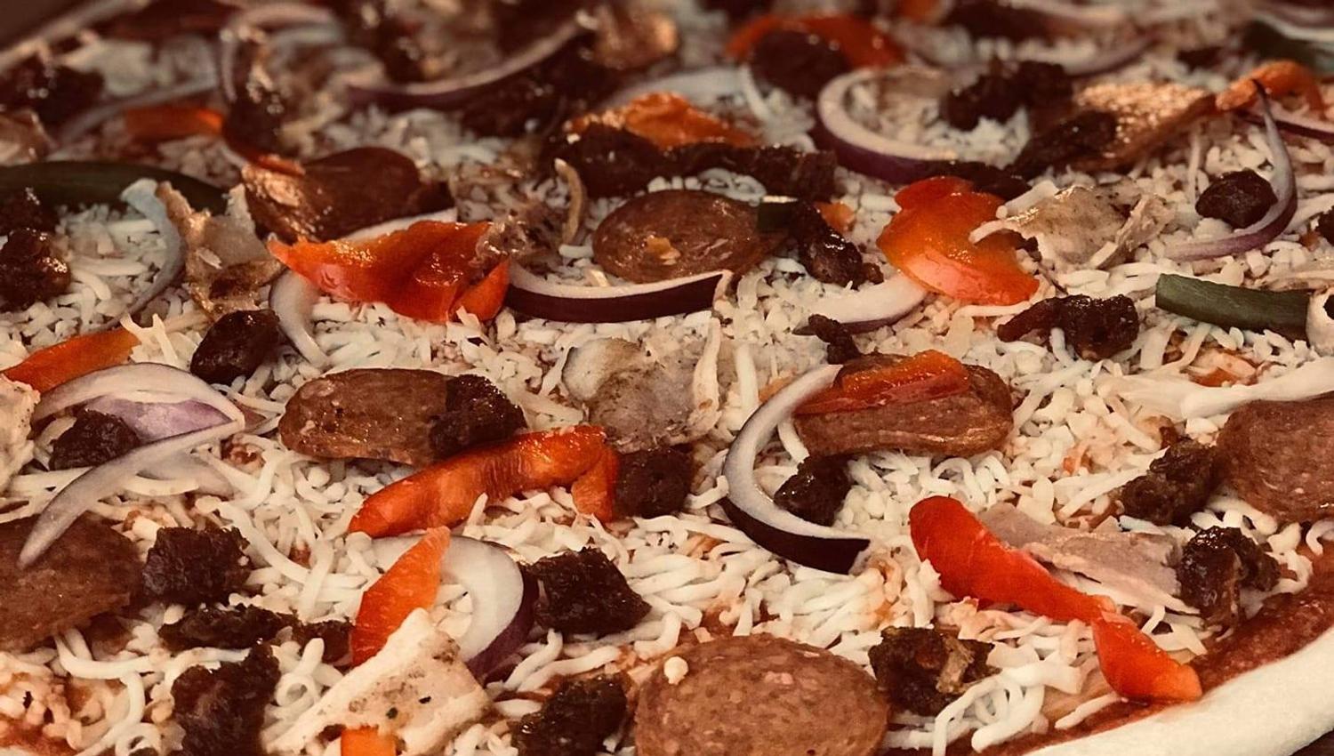 Homemade pizza ready for the oven, featuring rich flavors and quality ingredients.