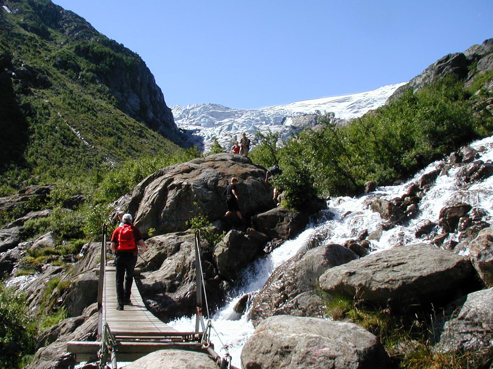 Hikers crossing a bridge over a river 