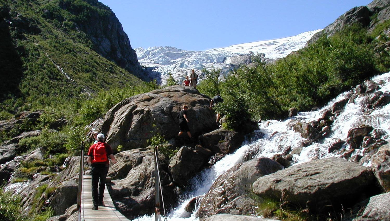 Hikers crossing a bridge over a river