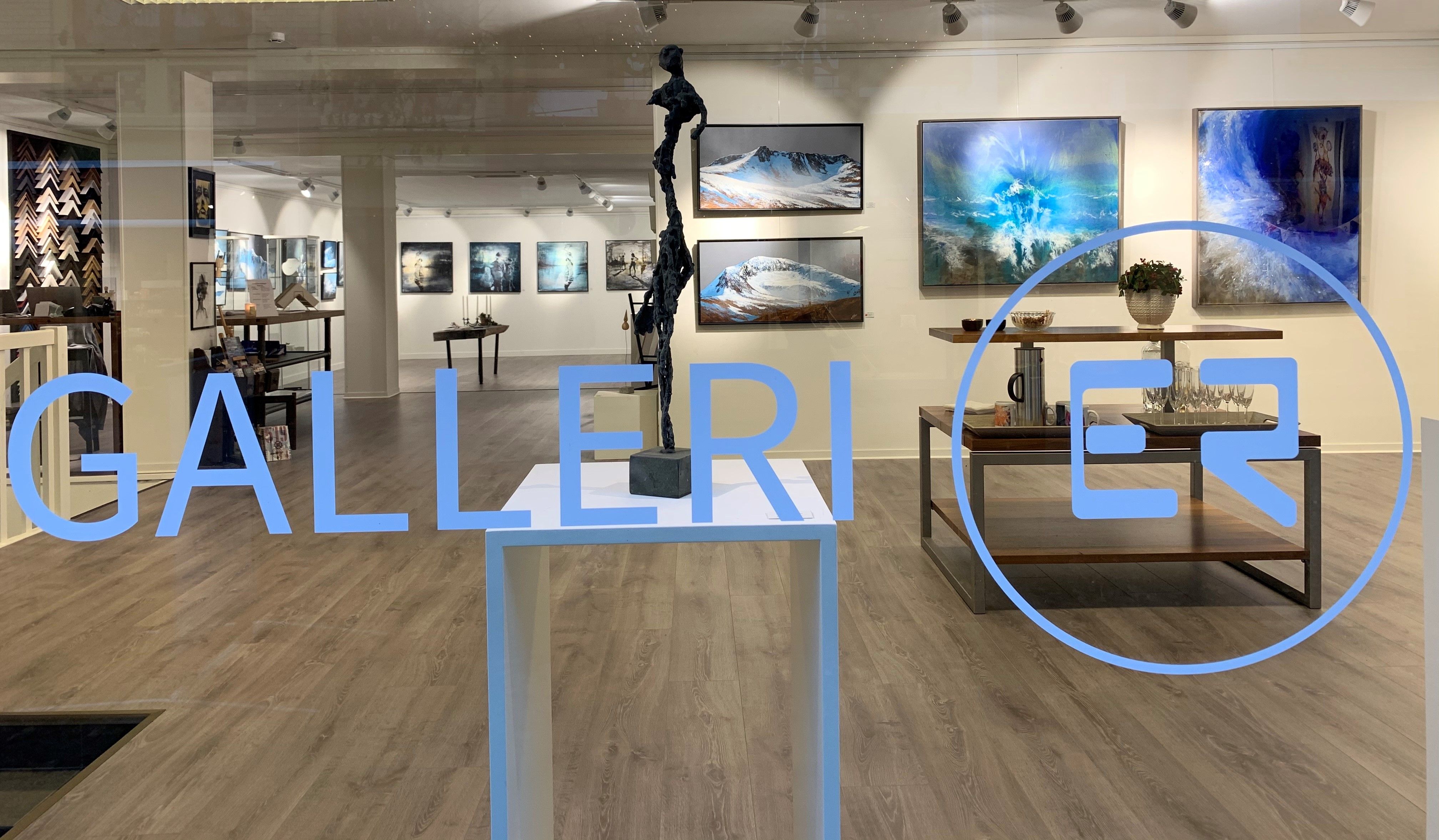 En titt inn i galleriet fra utsiden. Galleri ER skrevet på vinduet.