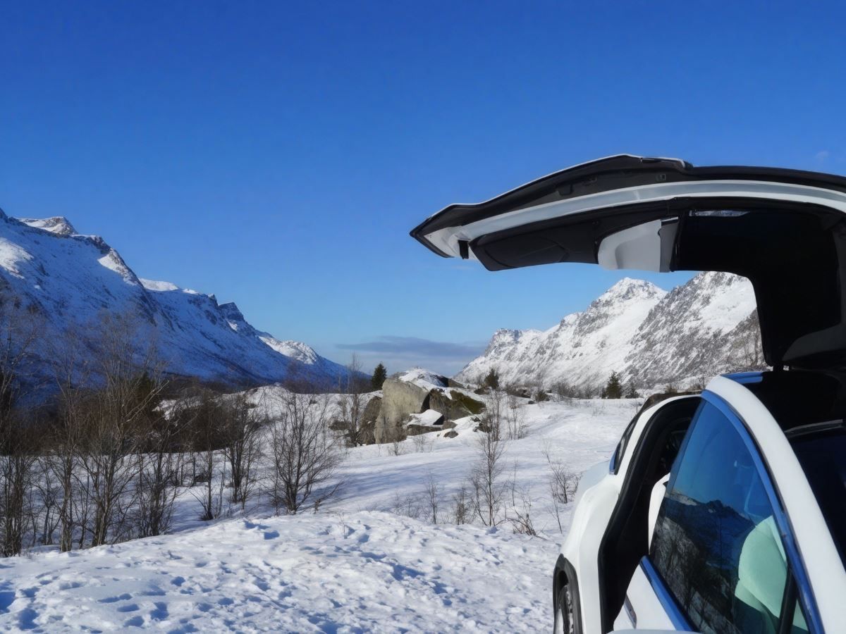 A Tesla with an open door and views of the surrounding landscape