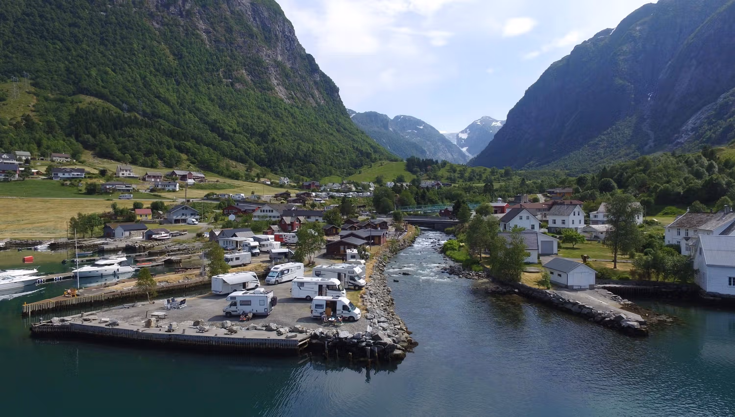 Campingvogner ved fjorden med roleg kveldsljos og utsikt mot fjella i Hardanger.