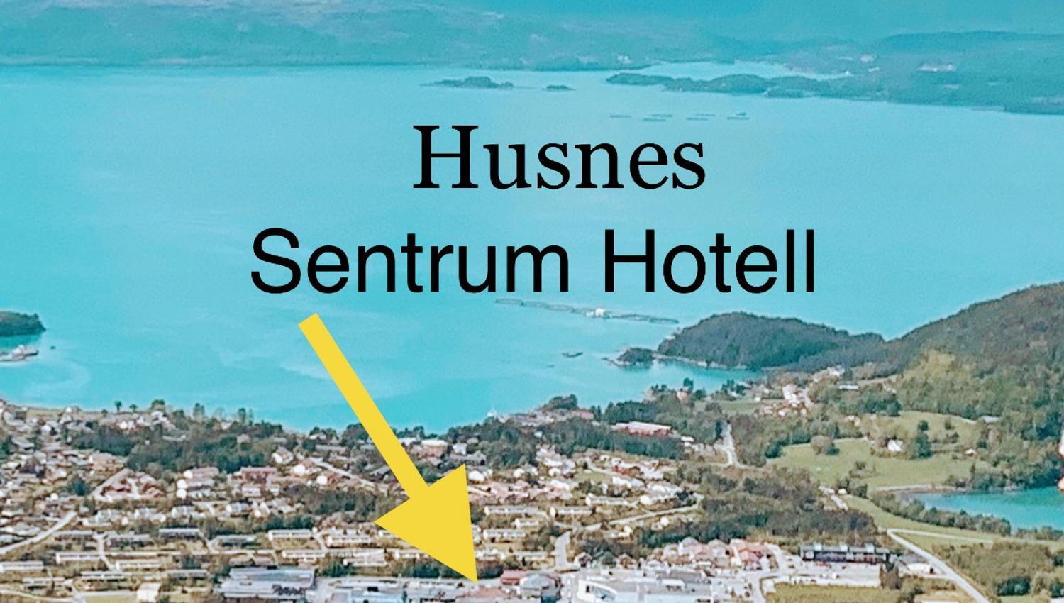 Aerial view of Husnes Sentrum, showing the location of Husnes Sentrum Hotell, surrounded by beautiful nature and fjord views.