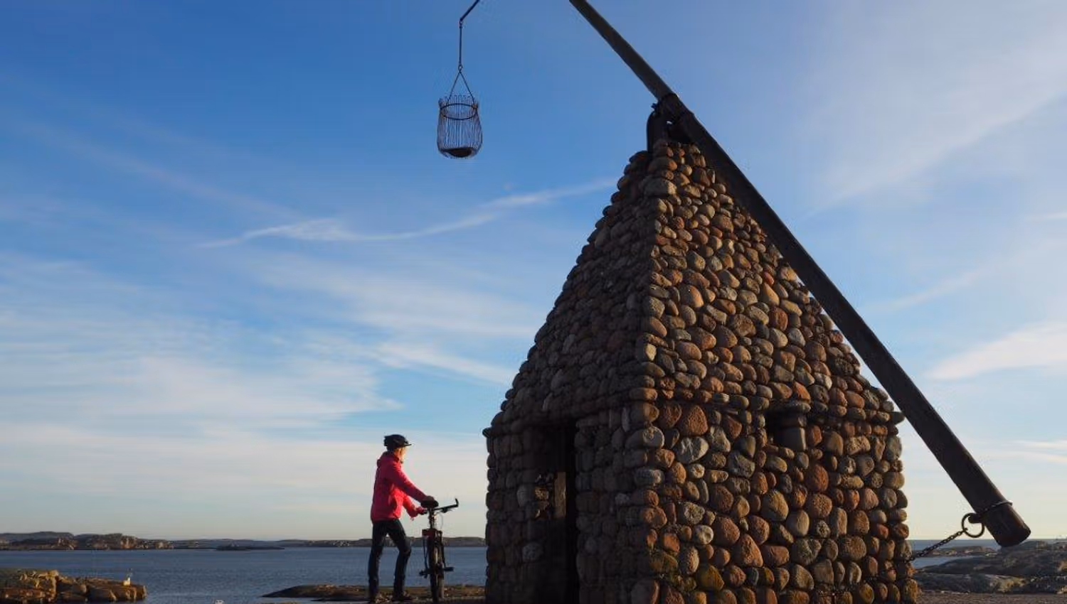 One with a bicycle by the tilting lighthouse at Verdens Ende