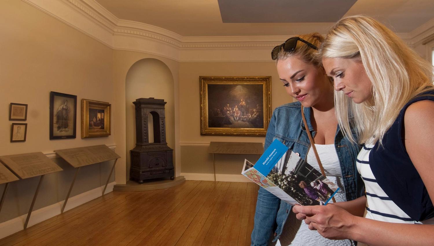 A couple looking at the Mandal Museum brochure.