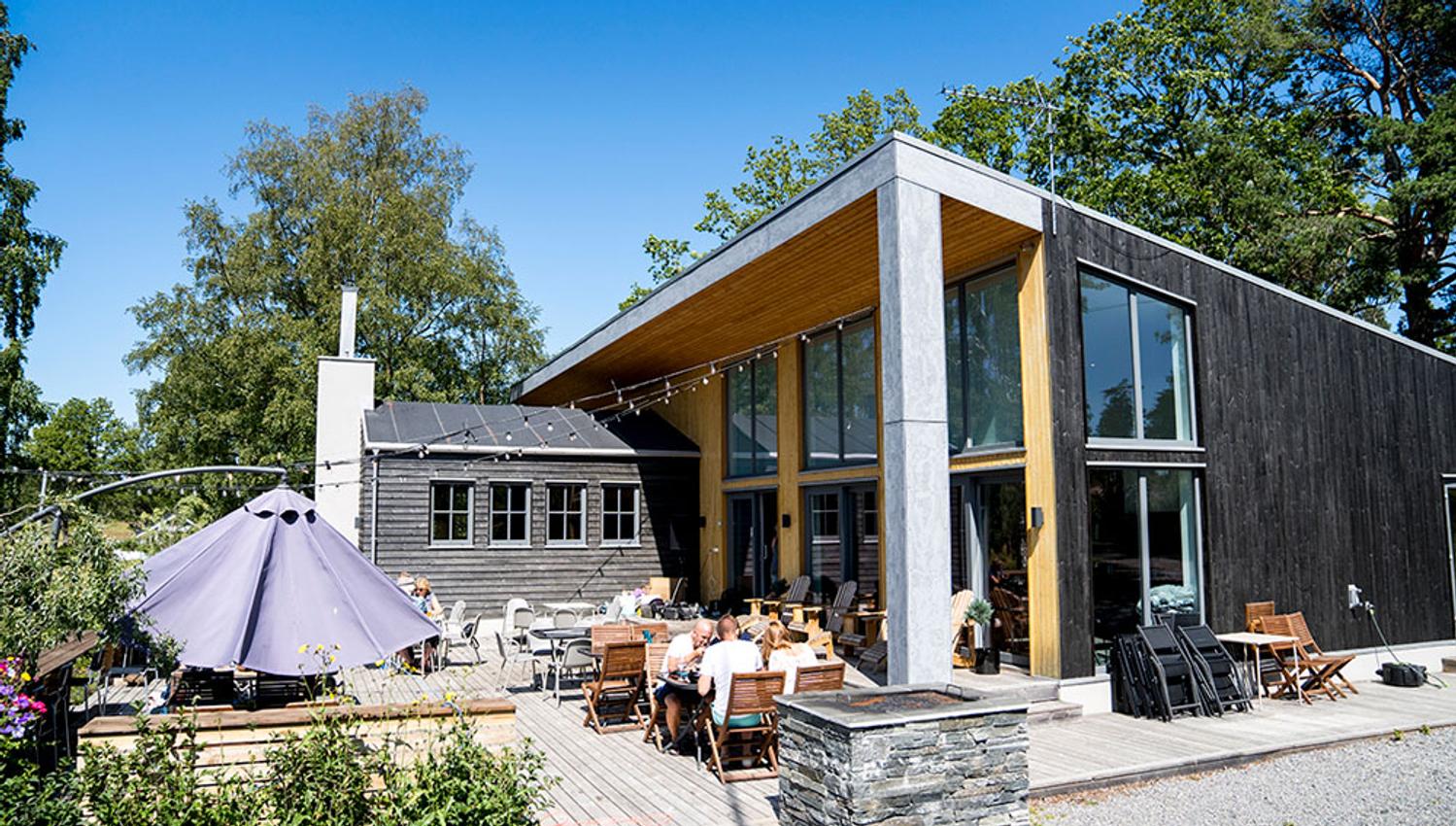 Villa Mat og Bar. Bilde av restauranthuset fra utstiden med terasse og gjester.