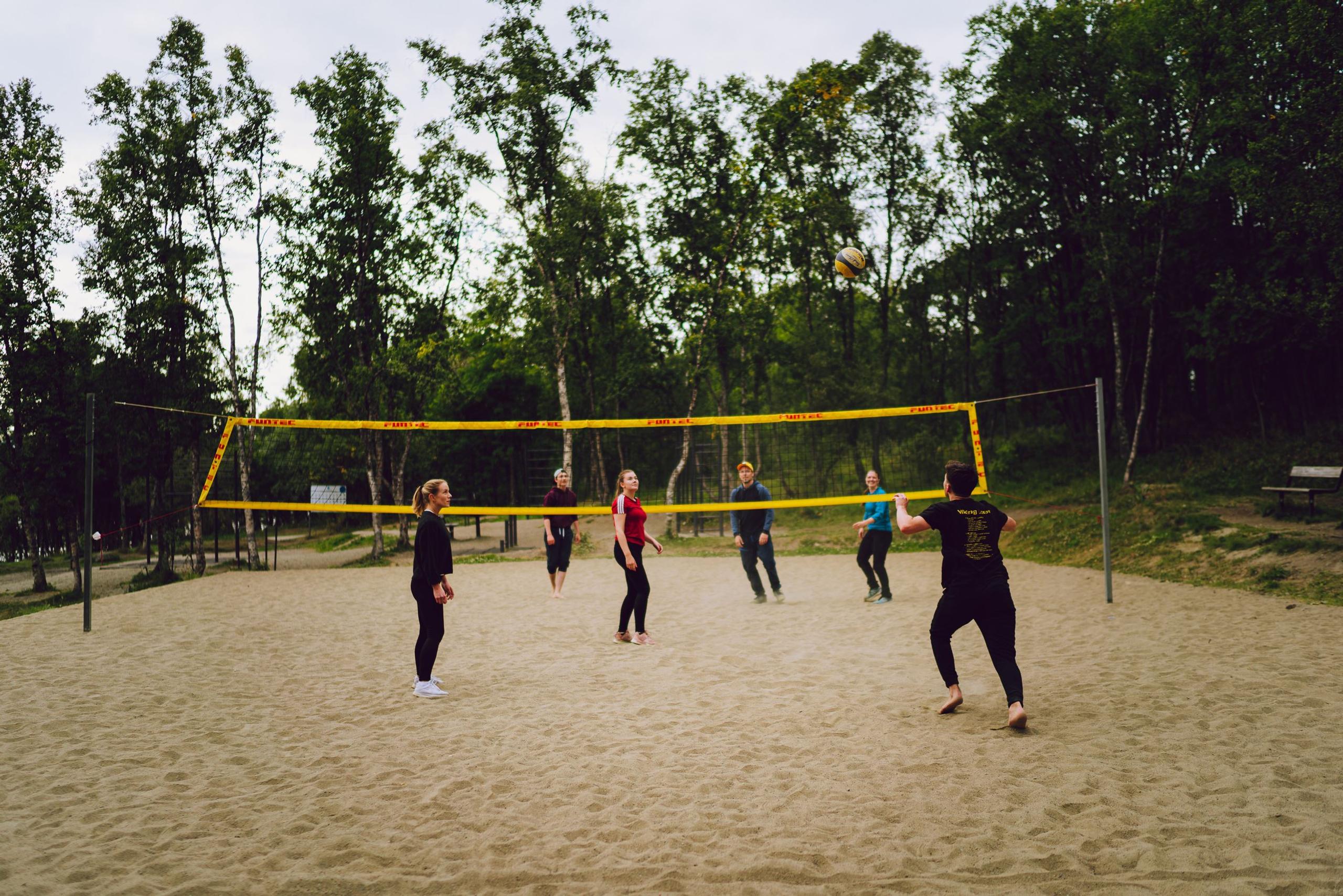 a group of friends playing sand volleyball 