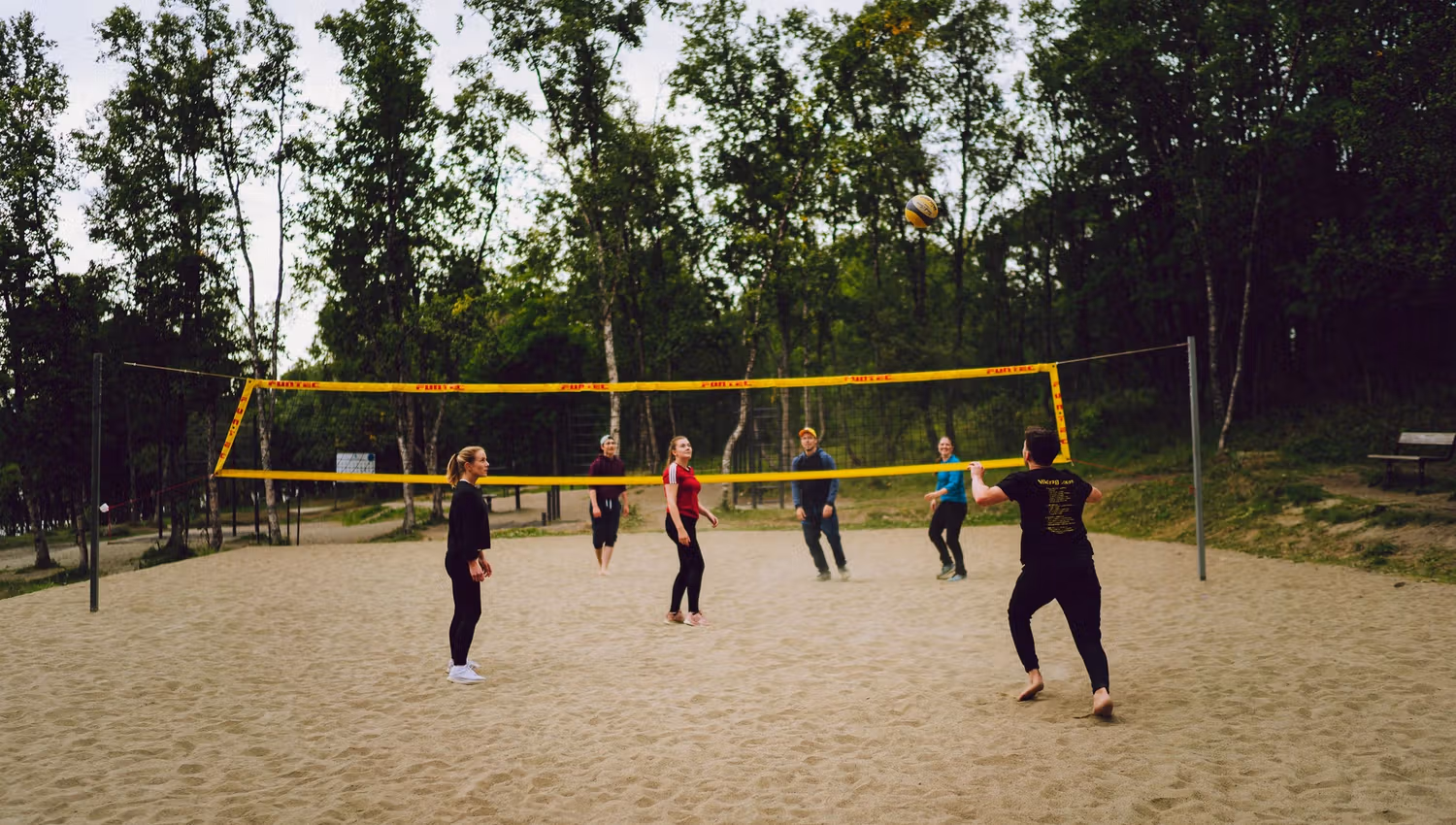 a group of friends playing sand volleyball
