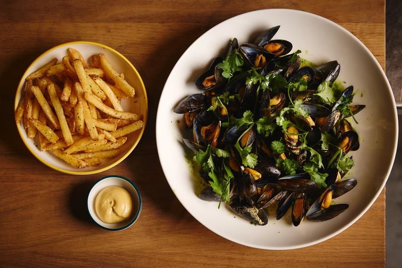 Detail of a bowl of mussels, a bowl of chips, and a bowl of mayonnaise