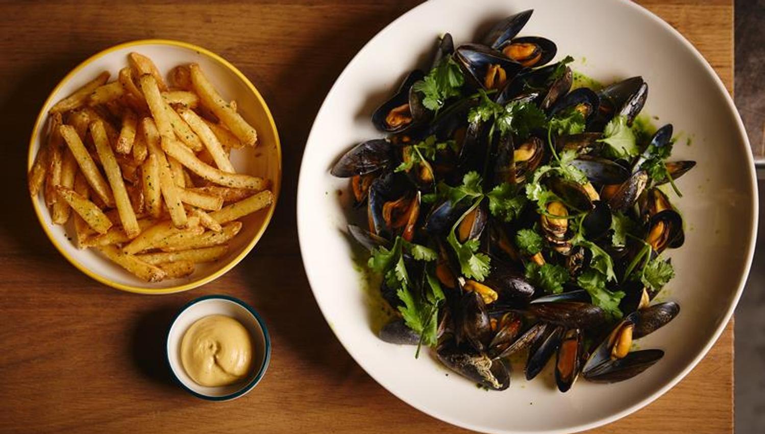 Detail of a bowl of mussels, a bowl of chips, and a bowl of mayonnaise