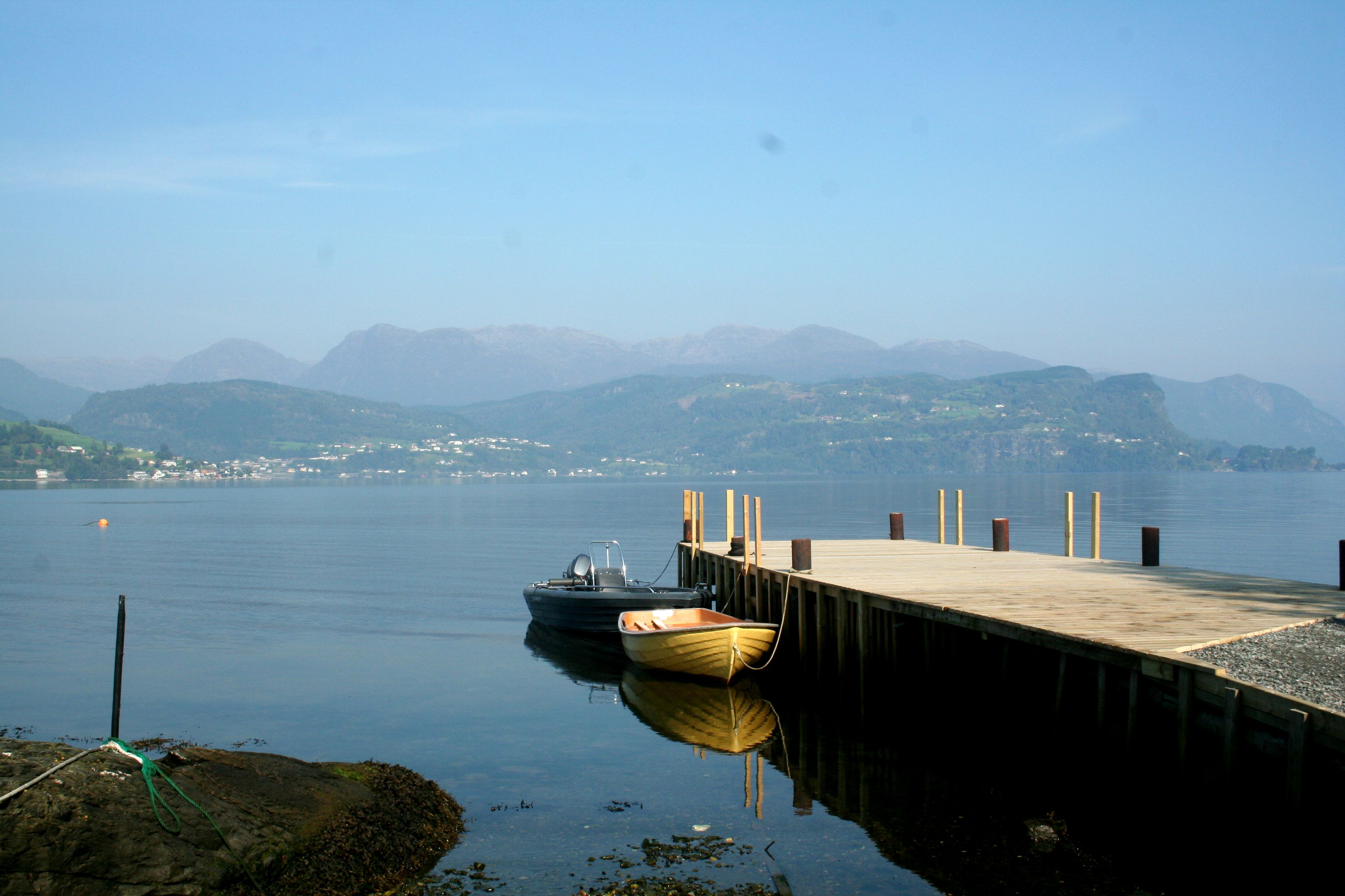 Pier and boats at Oddland Camping with views of the mountains and fjord landscape in Hardanger.