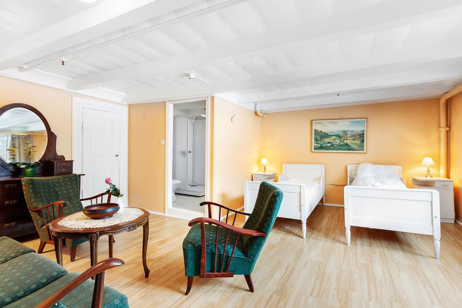 Room with twin beds and sitting area at Jaunsen Guesthouse in Hardanger.