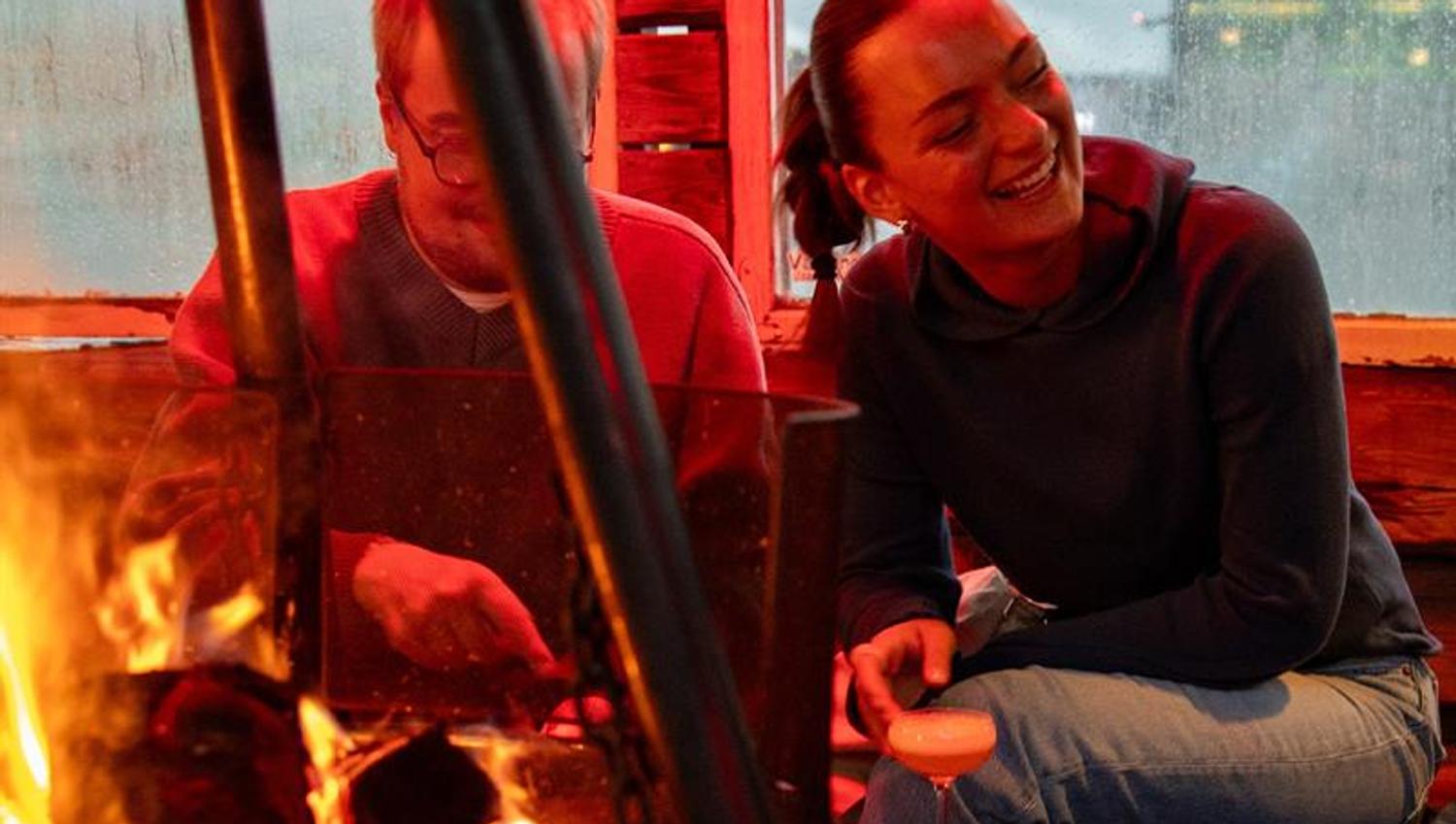 Two people sitting by the fire pit