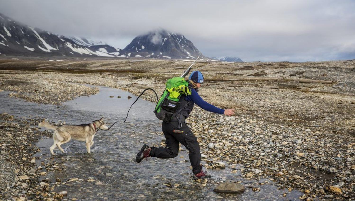 Guide med hund som hopper over et elveleie