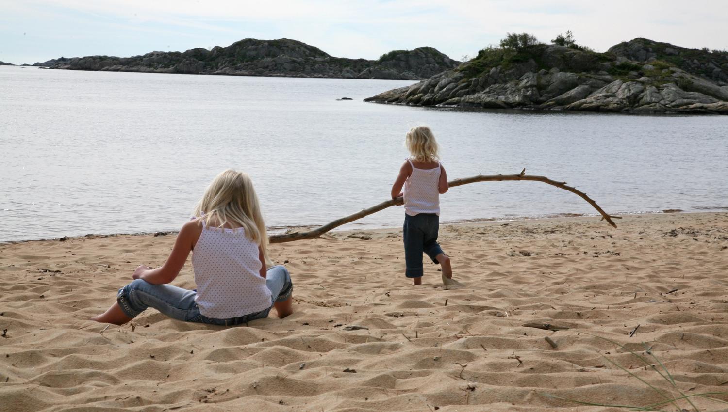 Kanelstranda, 2 barn leker med en trestokk