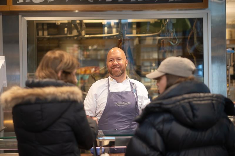 Employee behind the counter helping two customers