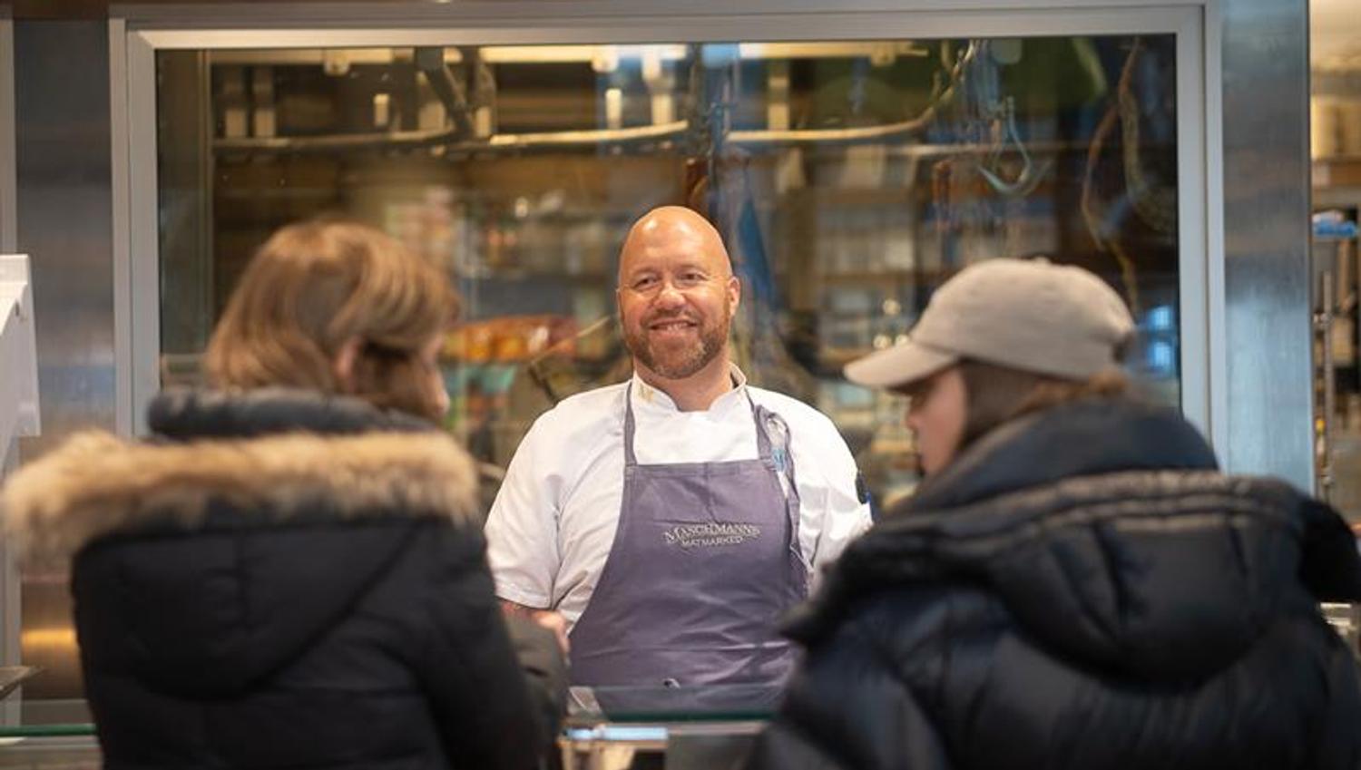 Employee behind the counter helping two customers