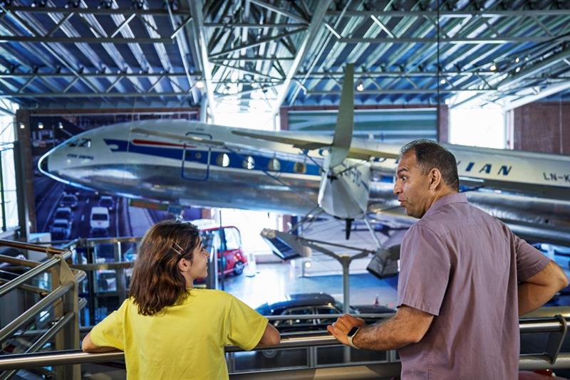 A man and a child looking at a plane