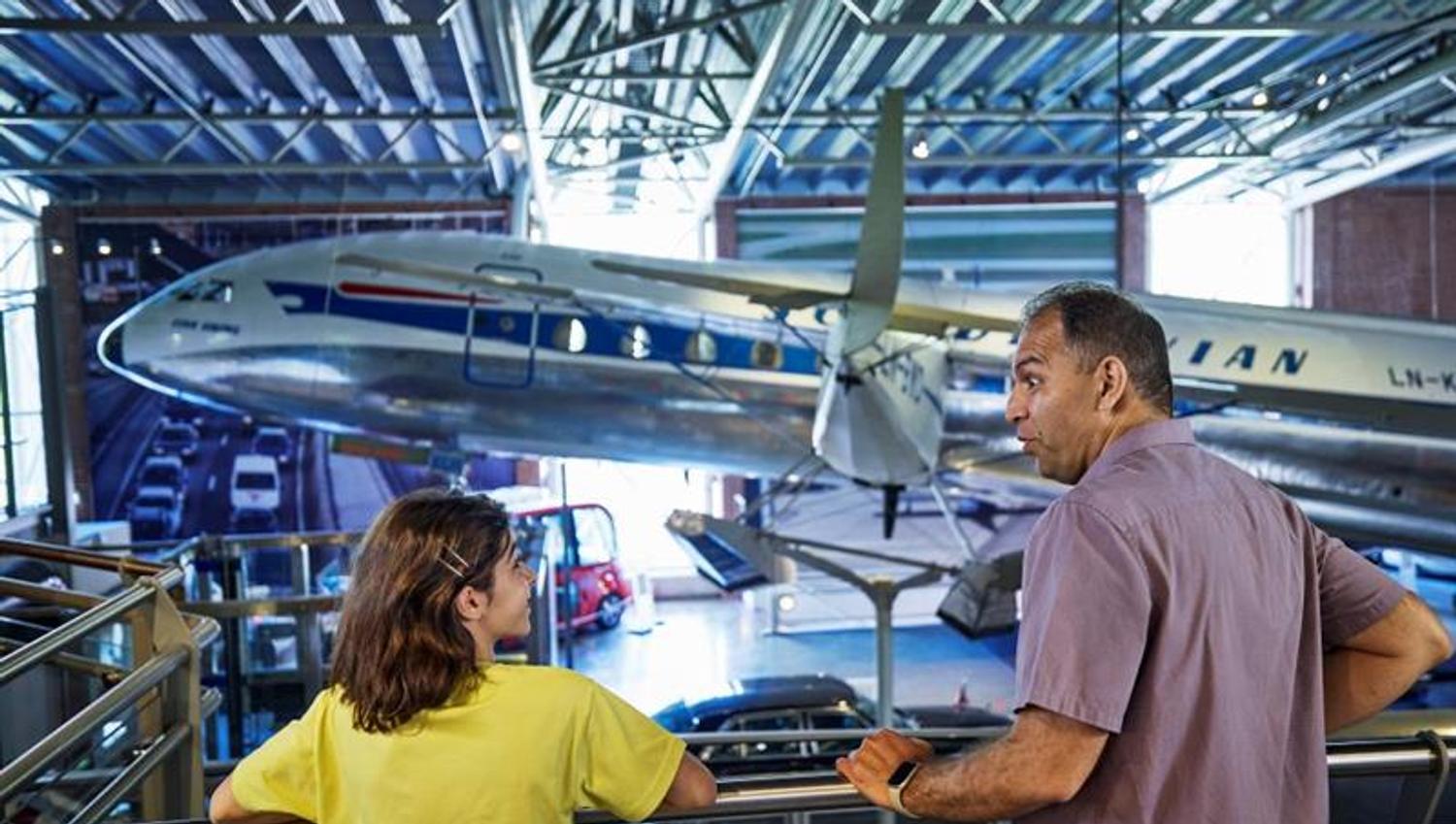 A man and a child looking at a plane