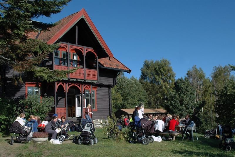 Mennesker som sitter foran et gammelt trehus.