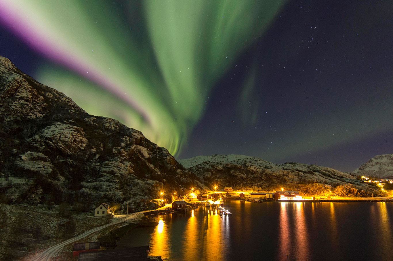 Northern light above fjord and Vesterålen fisherman's cabins