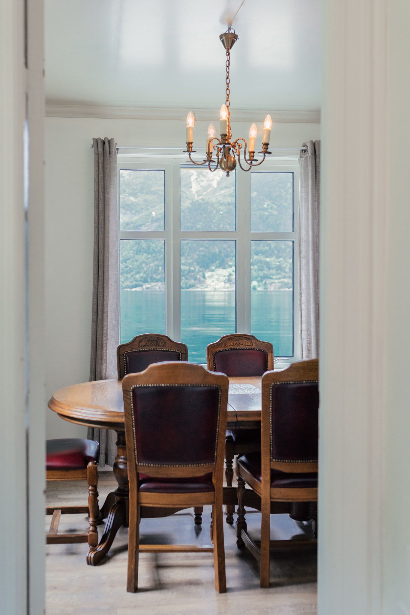 Dining room with panoramic view of the Hardangerfjord and Folgefonna glacier at Stana Farm – a peaceful and scenic place to dine.