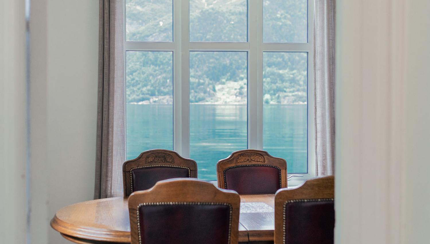 Dining room with panoramic view of the Hardangerfjord and Folgefonna glacier at Stana Farm – a peaceful and scenic place to dine.