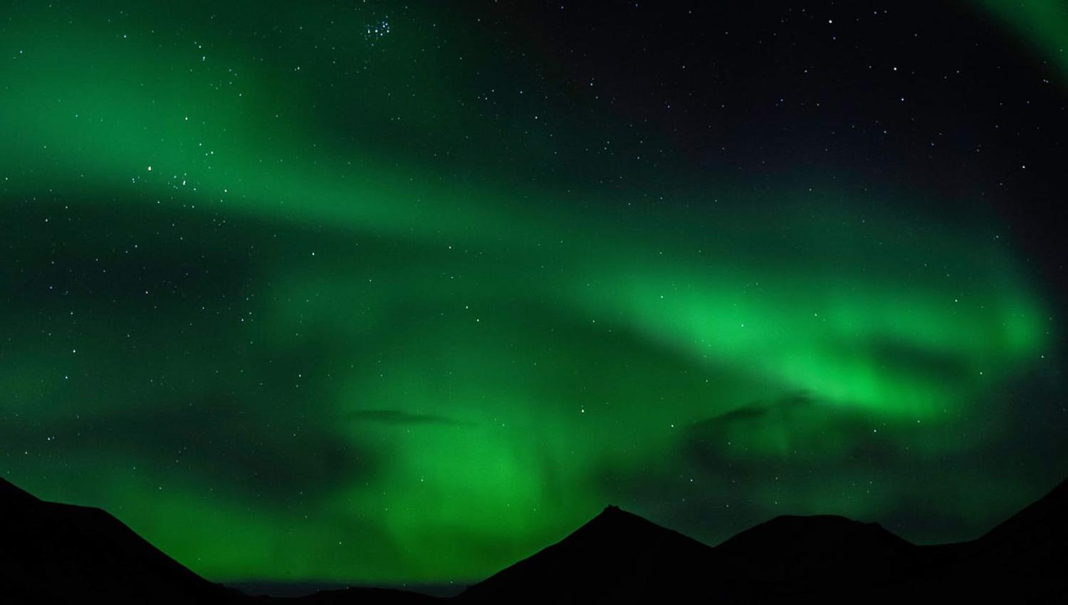 Northern lights shining above mountains