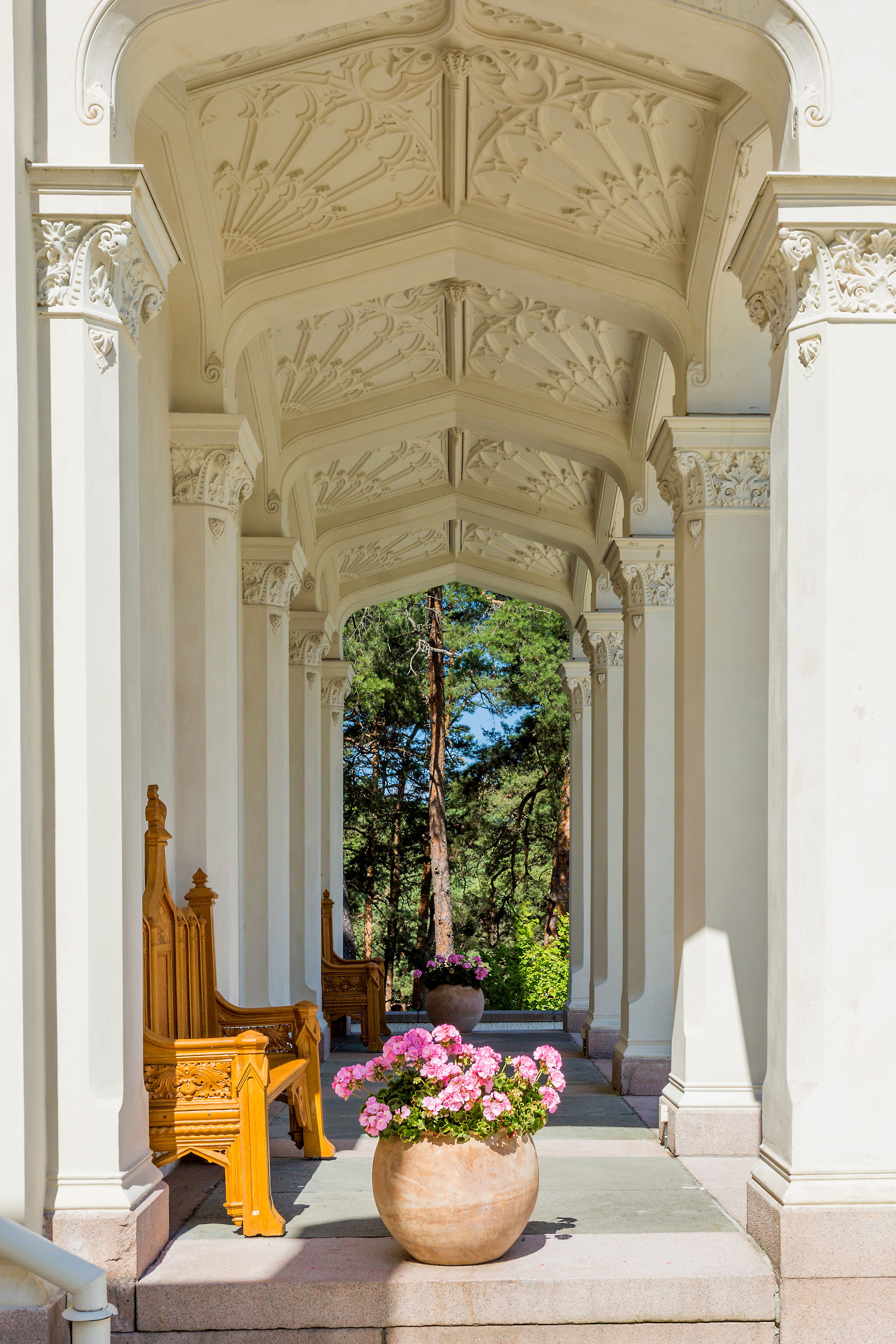 the hallway around the oscarshall with columns, ornate ceiling, flowers and benches 