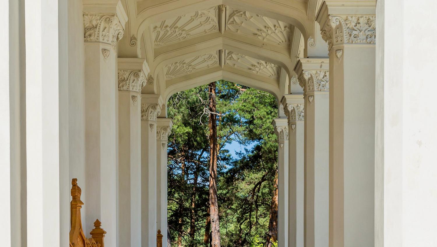 the hallway around the oscarshall with columns, ornate ceiling, flowers and benches
