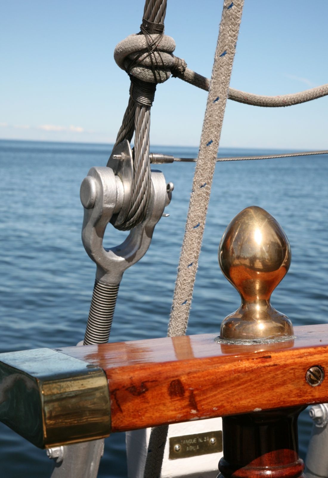 Detaljbilde av seil, med havet i bakgrunnen.