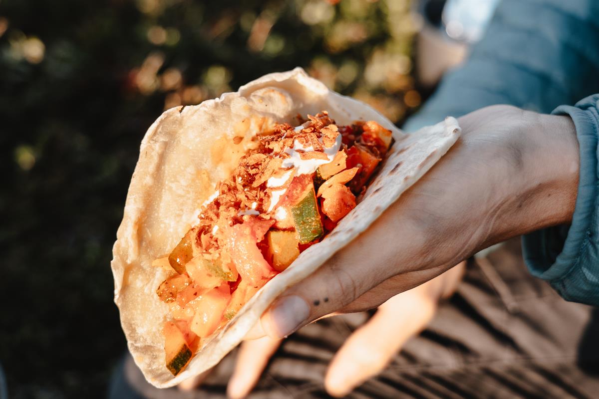 Hand holding a vegetable-filled wrap