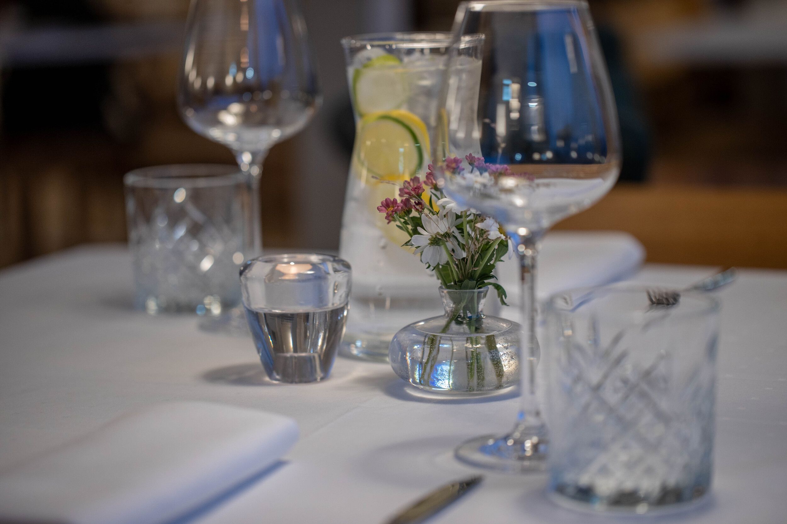 Dekket bord med hvit duk og glass