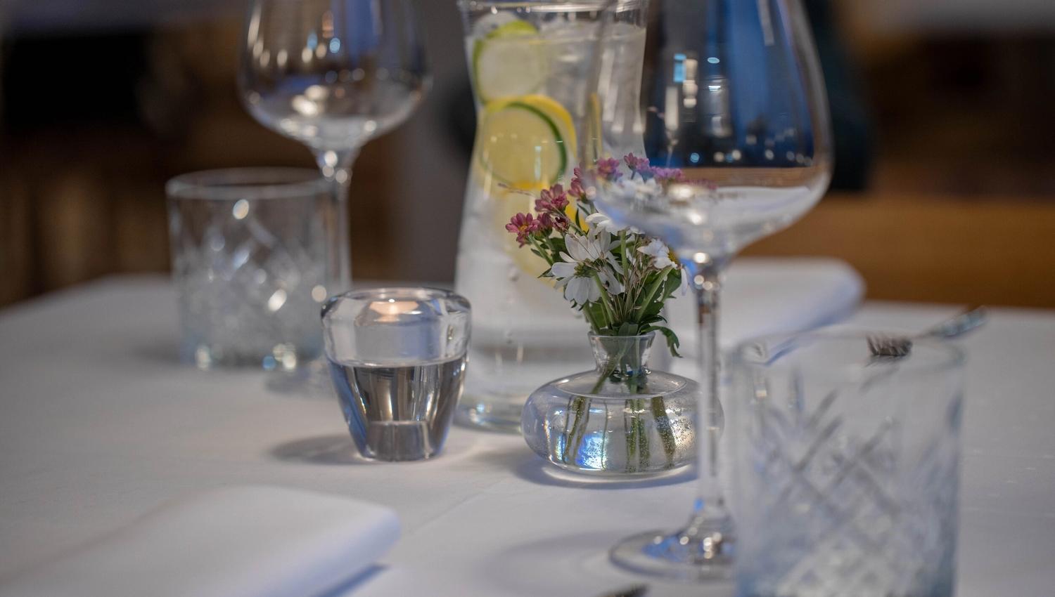 Dekket bord med hvit duk og glass