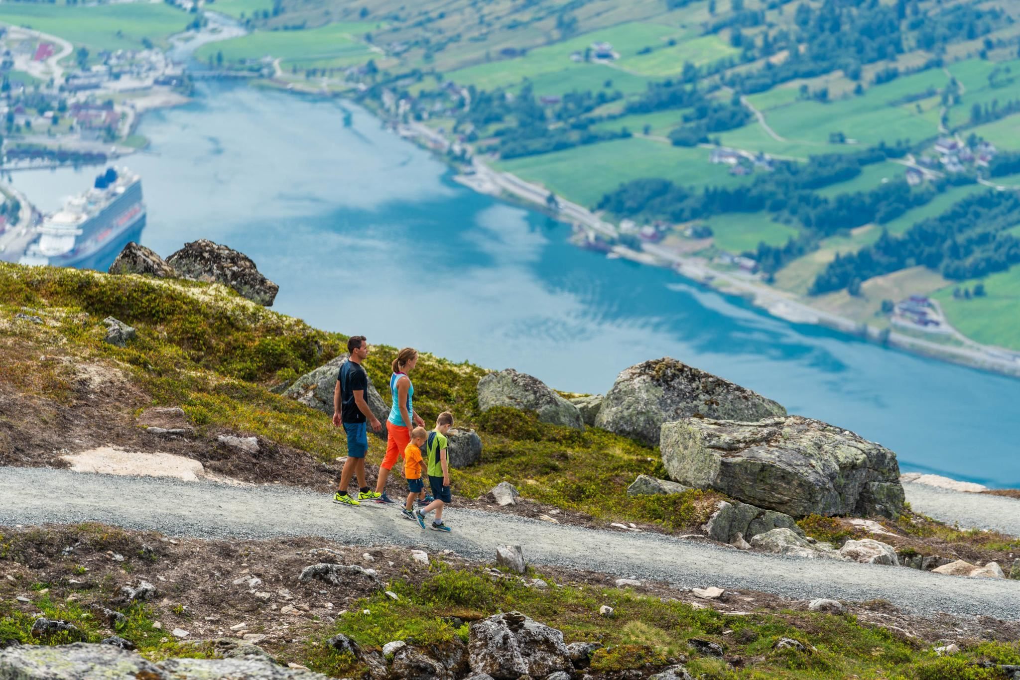 Hikers on a mountain trail at Hoven, with views over the fjord and surrounding landscape.