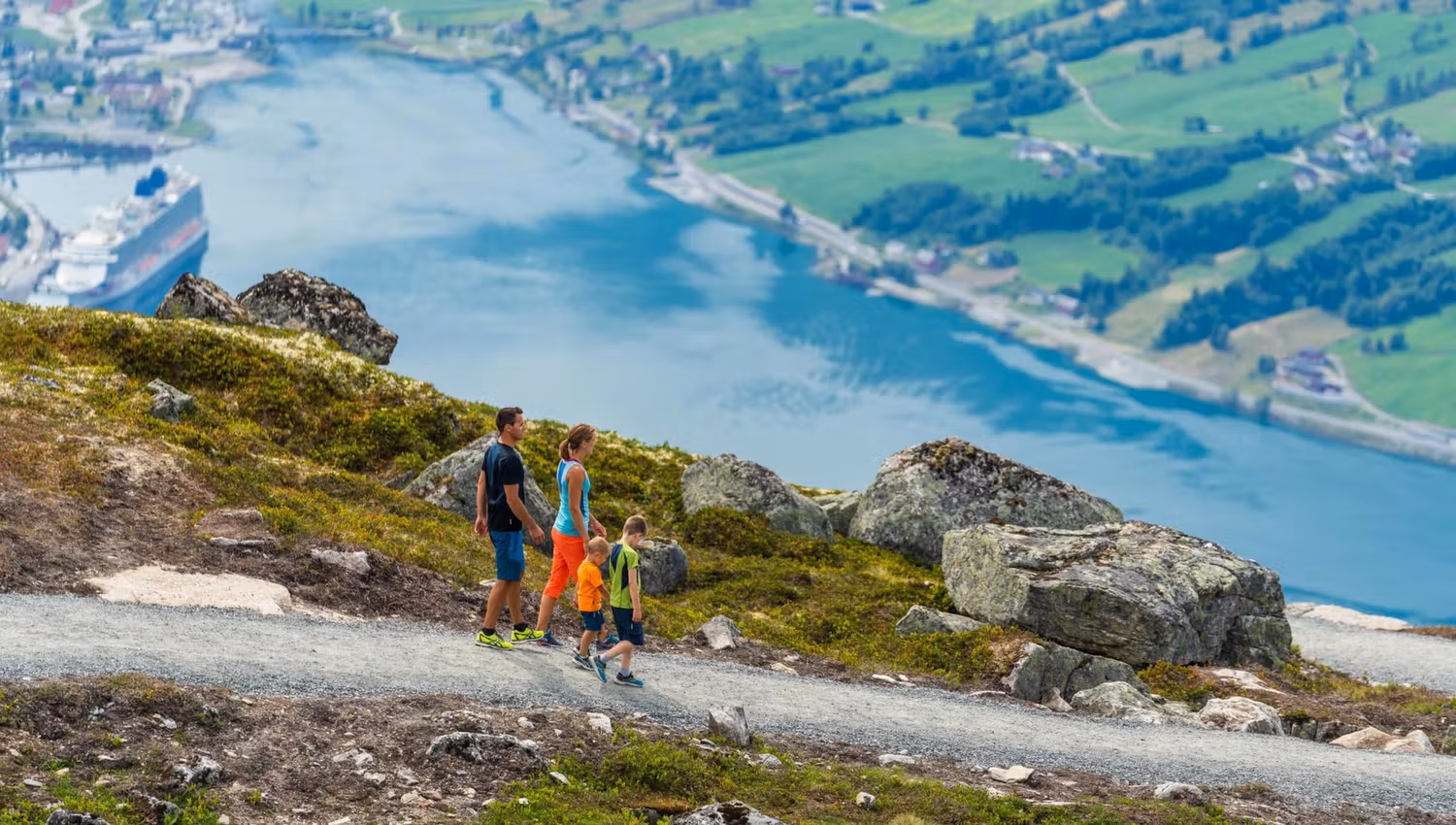 Hikers on a mountain trail at Hoven, with views over the fjord and surrounding landscape.