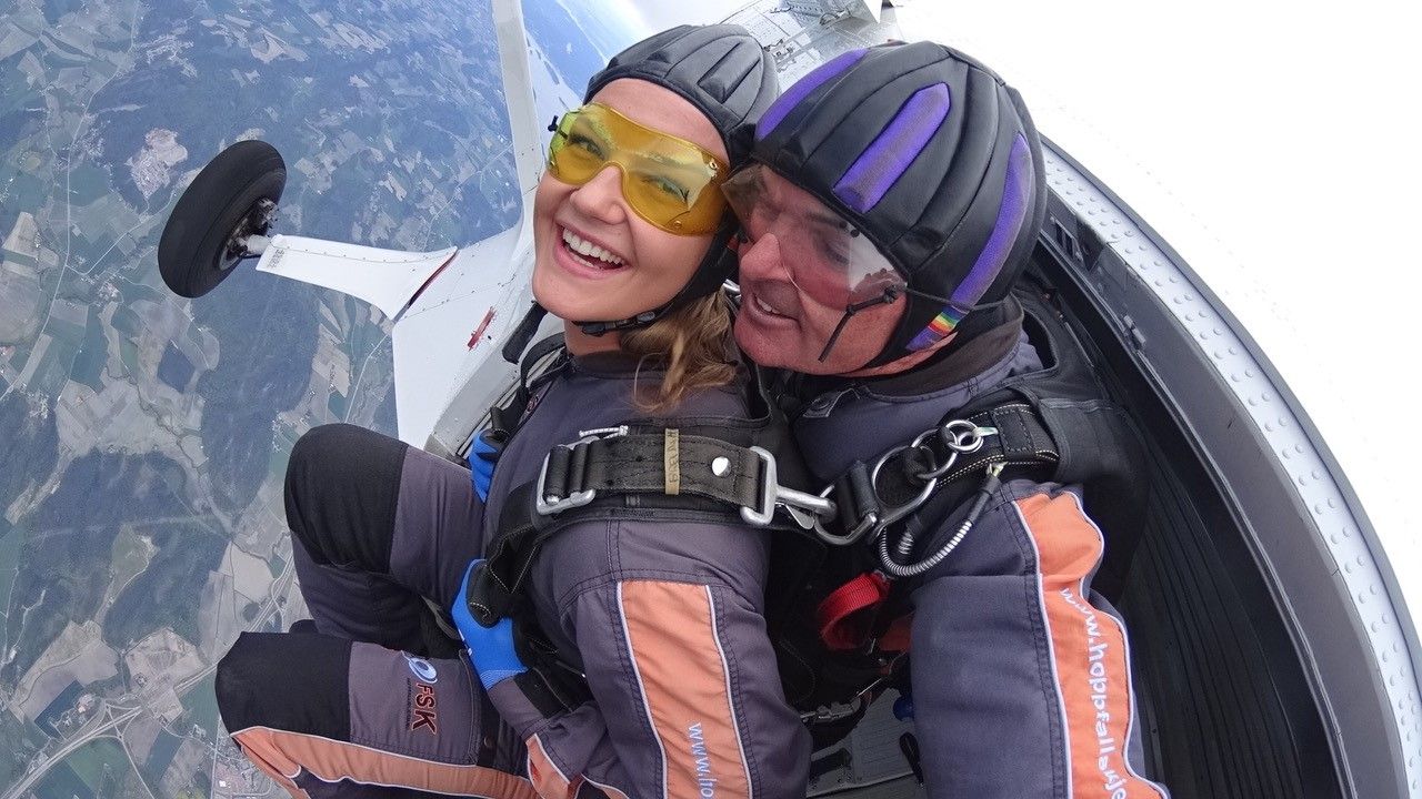 Two happy people on their way out of the plane in the air