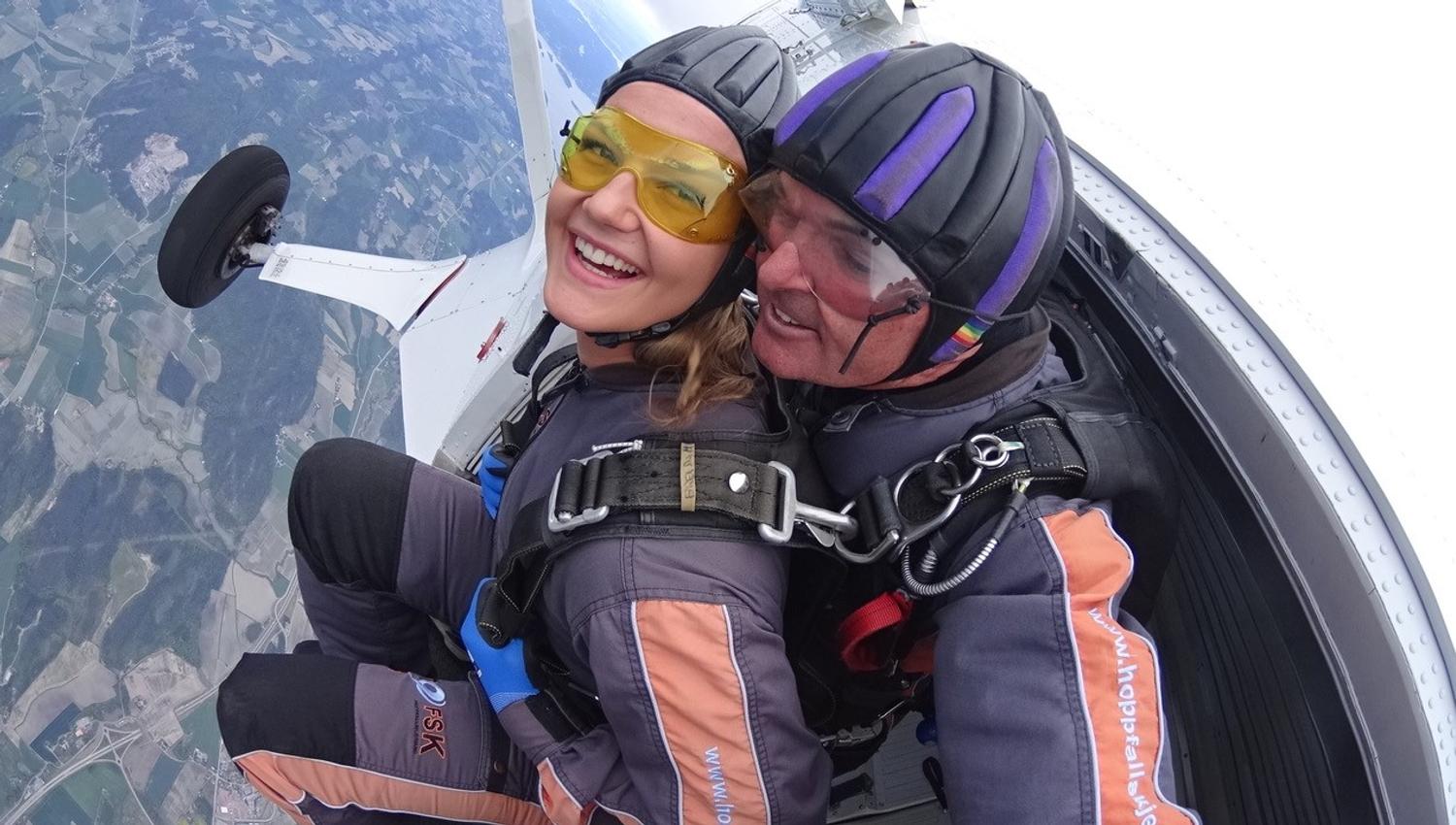 Two happy people on their way out of the plane in the air