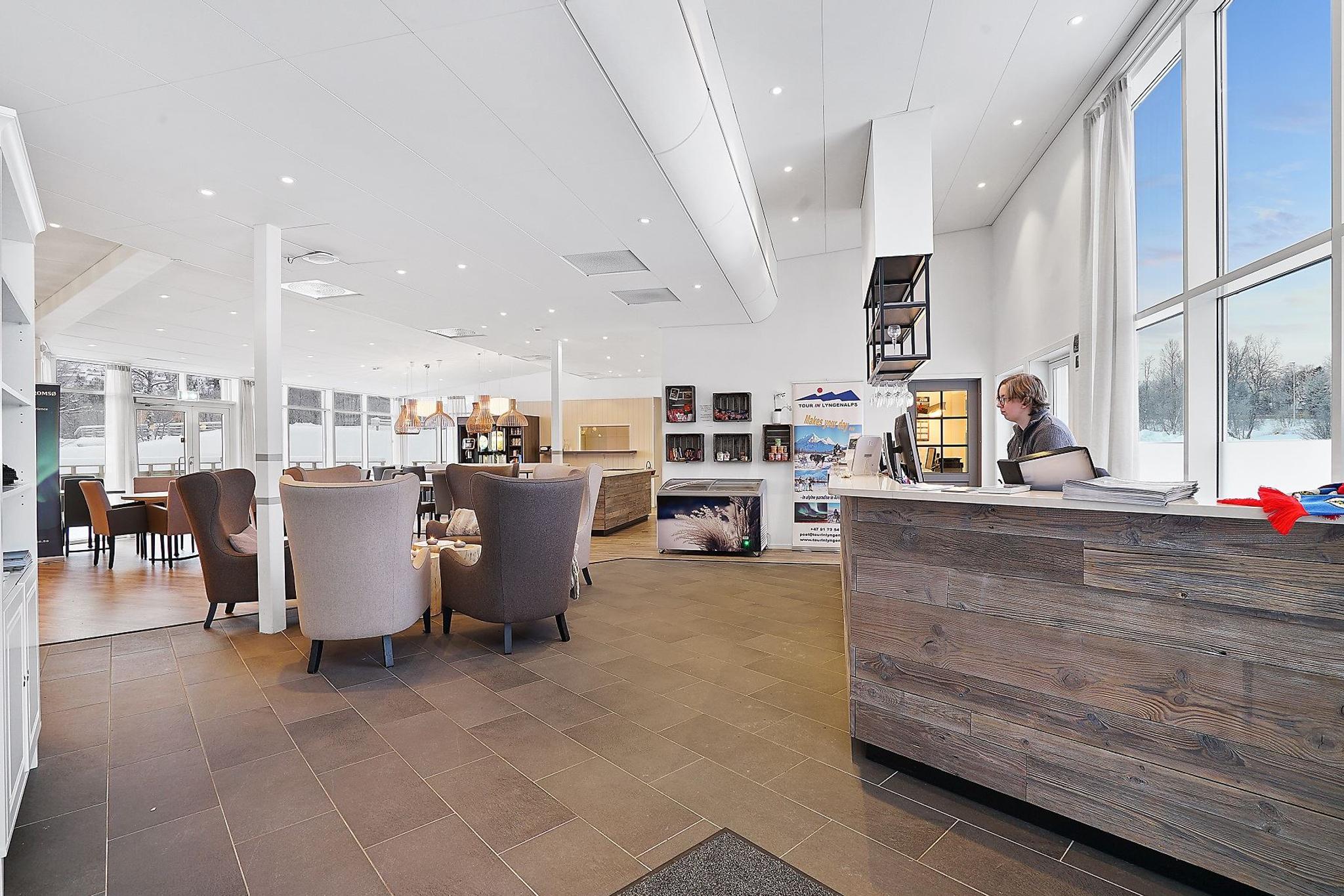 Moderne resepsjonsområde med sittegruppe og store vinduer