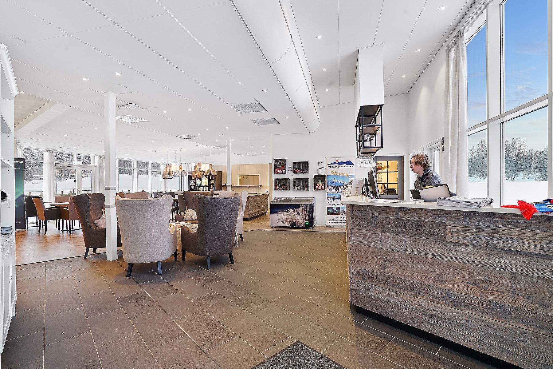 Moderne resepsjonsområde med sittegruppe og store vinduer