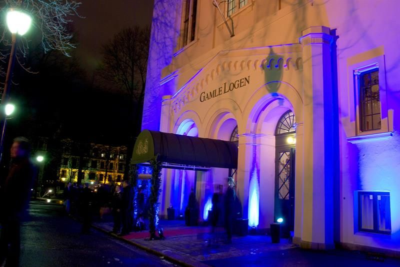 Exterior in the evening, with blue neon lights that illuminate the building.