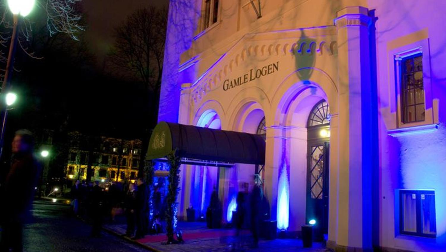 Exterior in the evening, with blue neon lights that illuminate the building.