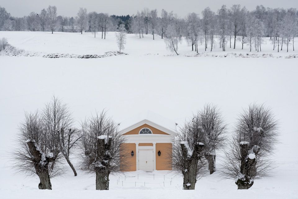 A small yellow house in a snow-covered scenery.