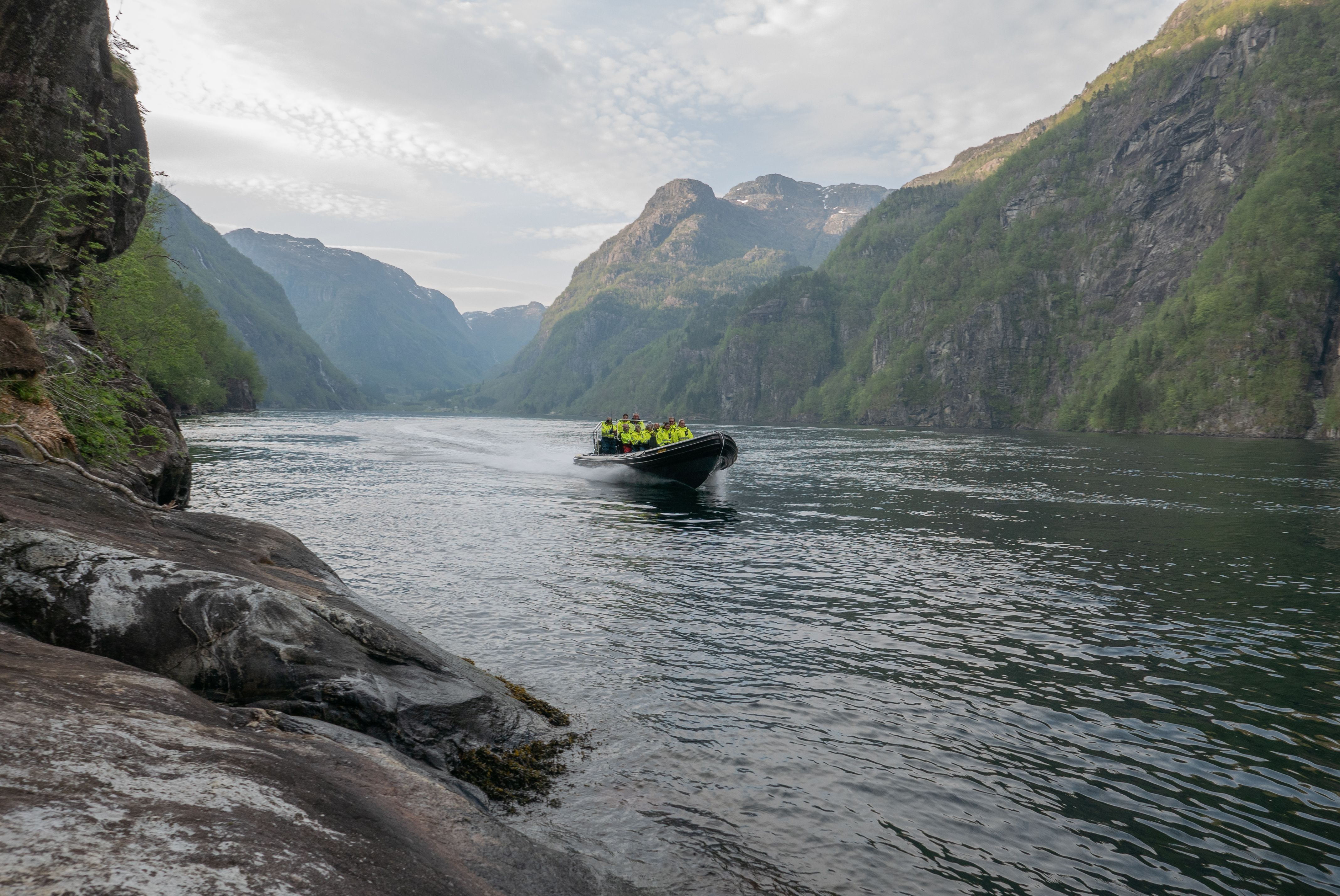 A RIB boat cruising through the dramatic fjord landscape of Hardanger, an unforgettable experience.