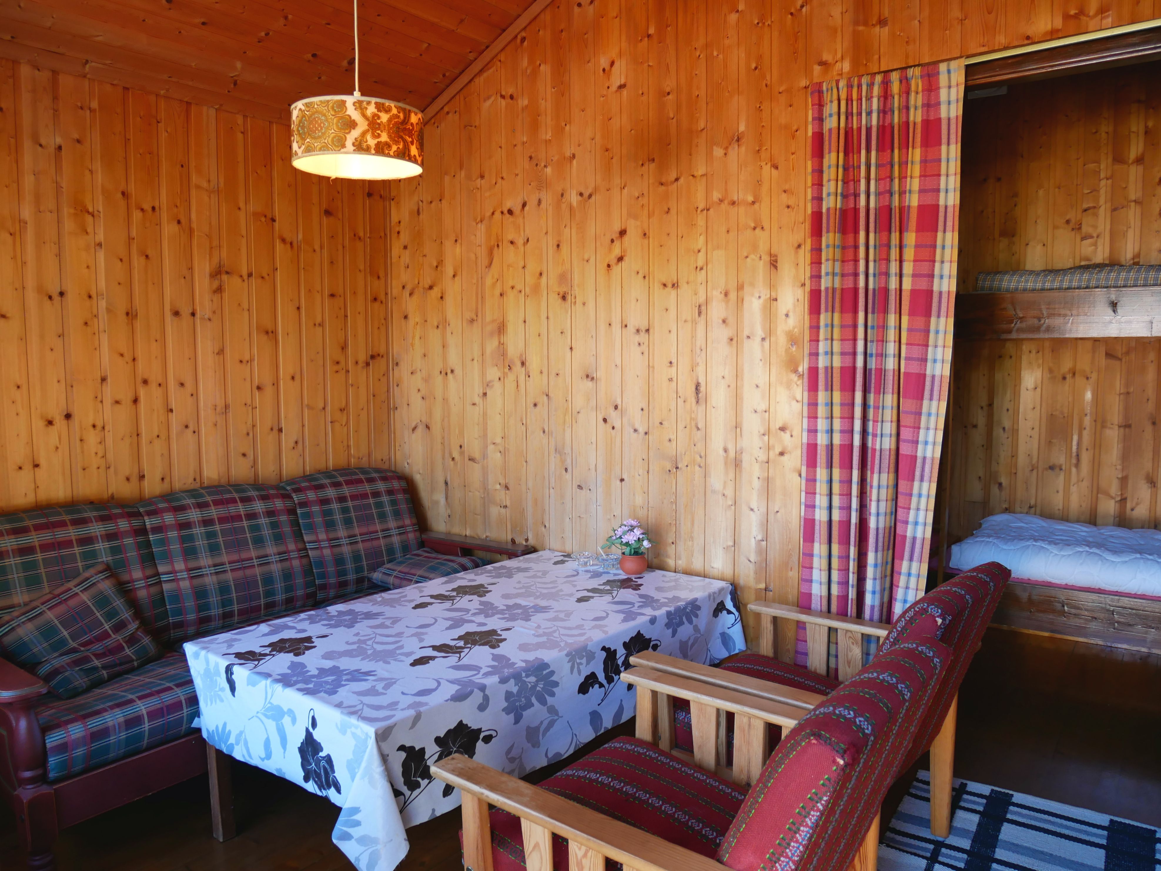 Lita hytte med enkel og koseleg stove, perfekt for rolege kveldar på camping.