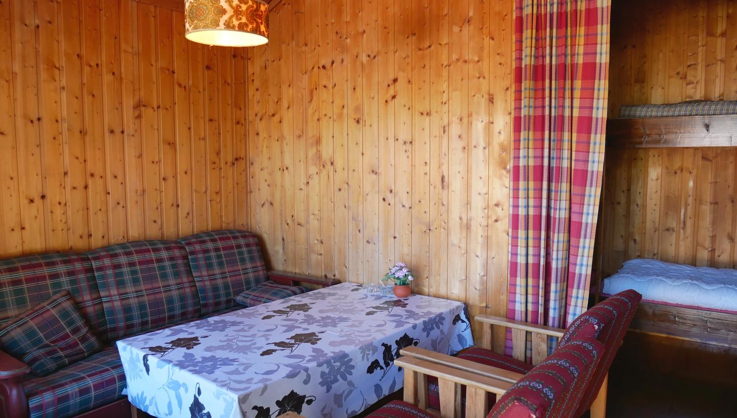 Lita hytte med enkel og koseleg stove, perfekt for rolege kveldar på camping.