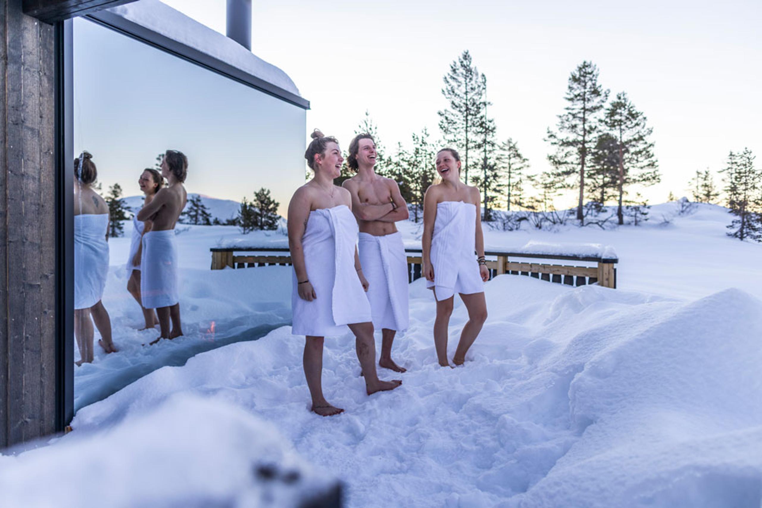 3 unge mennesker i snøen foran Panorama badstu