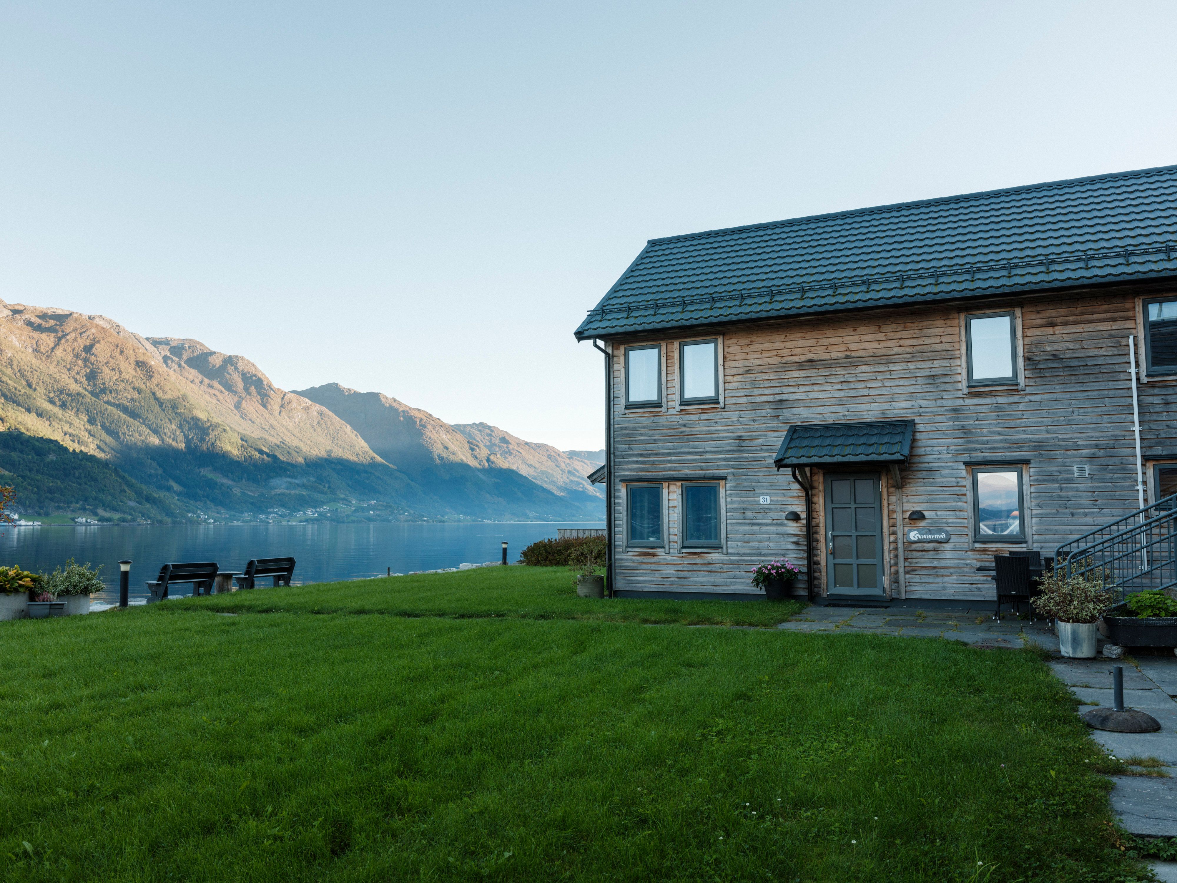 Guests enjoying the evening by the fire pit at Aga Fjordapartments overlooking the Hardangerfjord.