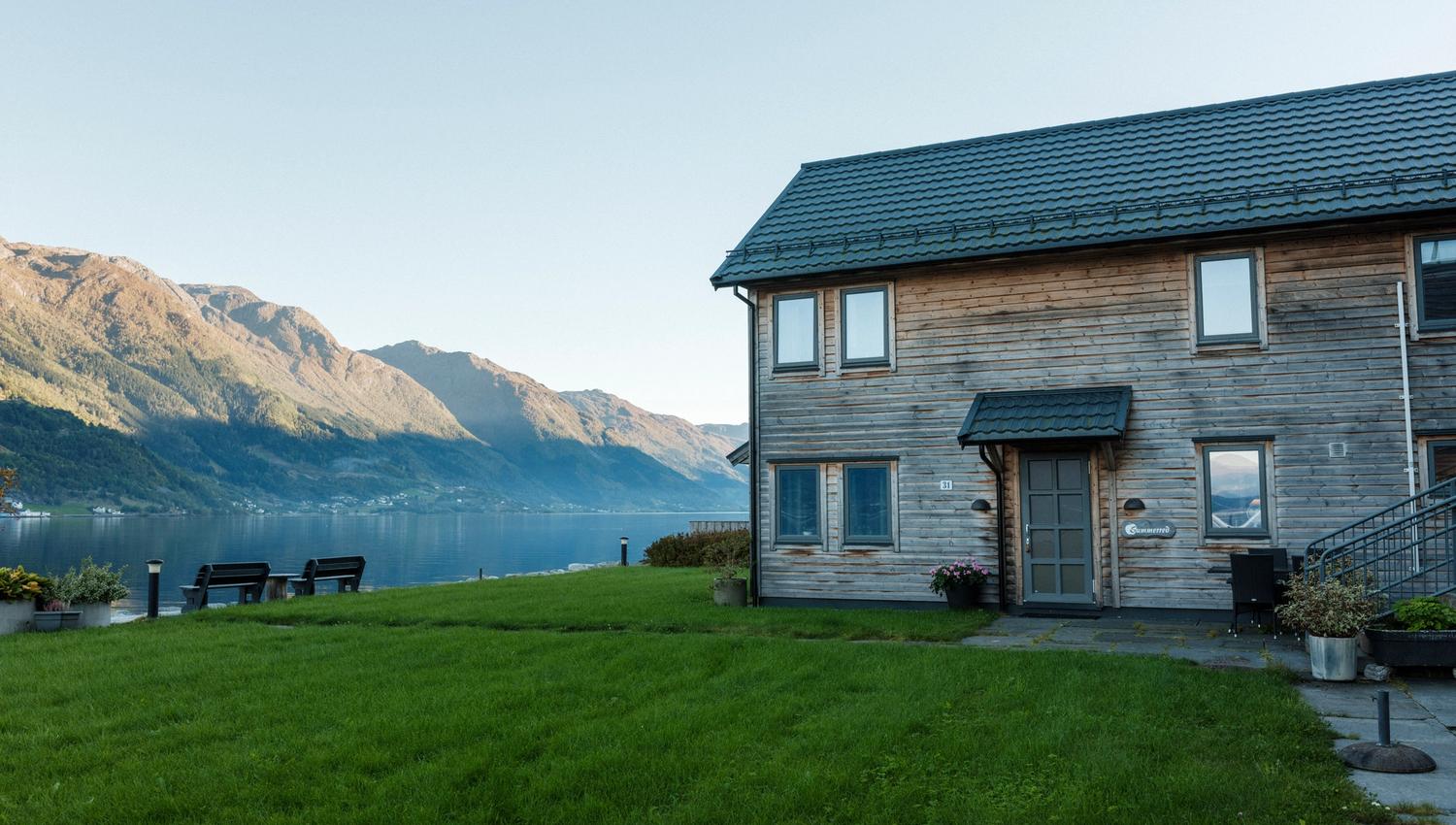 Guests enjoying the evening by the fire pit at Aga Fjordapartments overlooking the Hardangerfjord.
